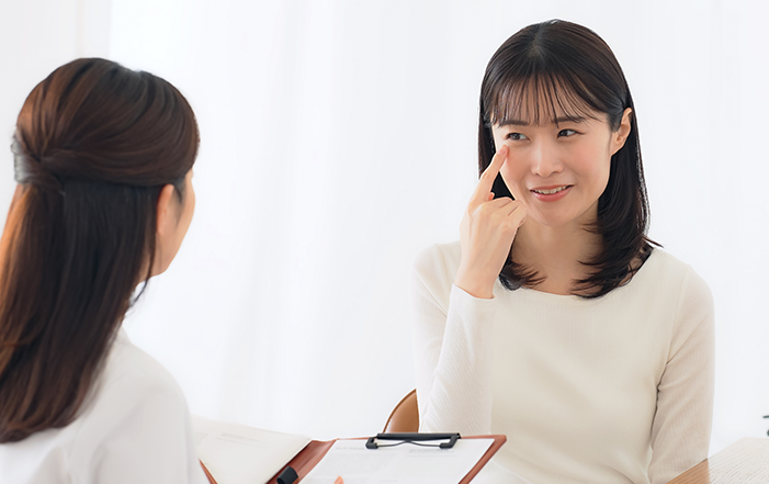 A woman discussing eyebag surgery with her doctor