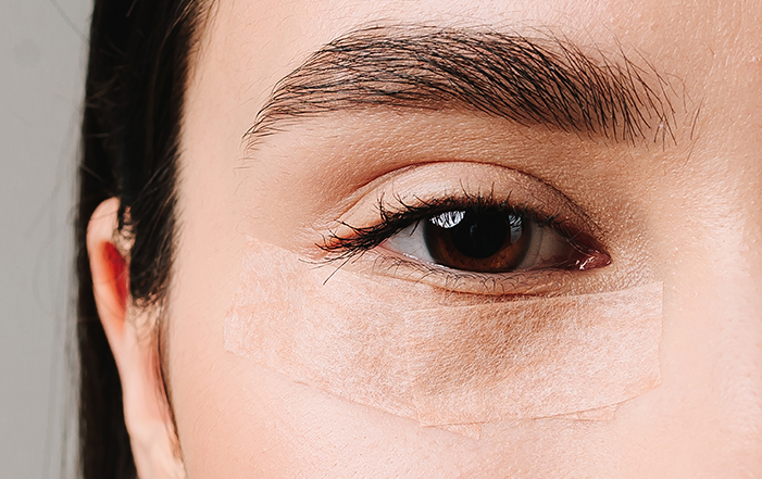 A woman with bandages under her eyebags