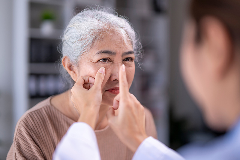Woman consulting a plastic surgeon about droopy eyelid surgery