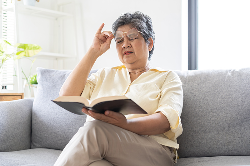 Woman with ptosis experiencing difficulty while reading