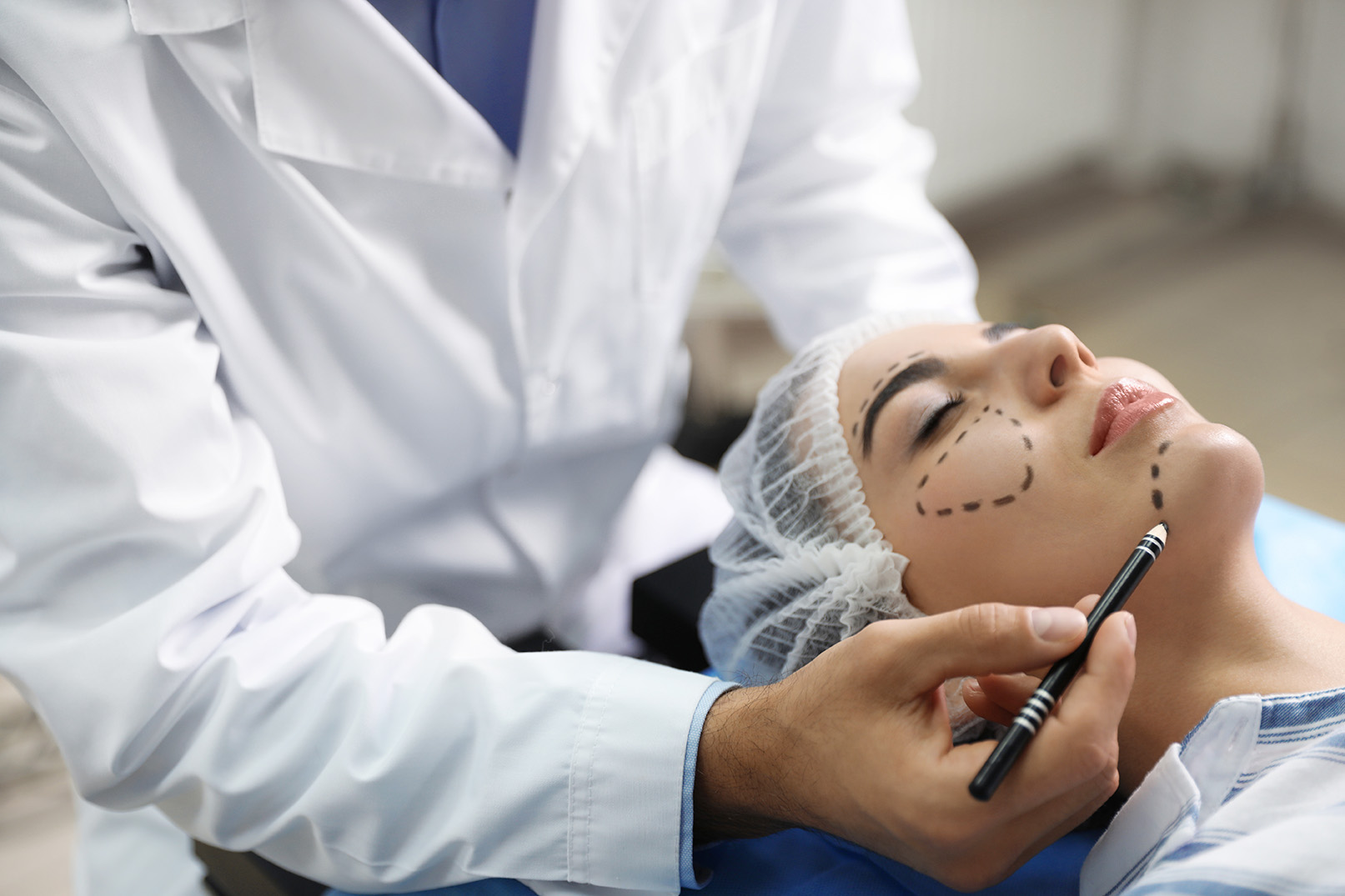 Plastic surgeon preparing patient for cosmetic procedure
