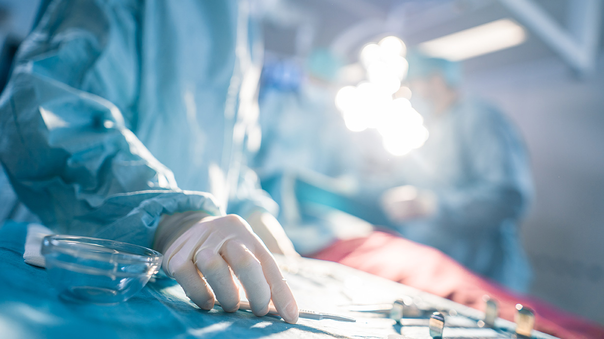 A plastic surgeon performing surgery on a patient in the operating room.